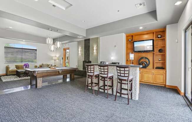 A spacious living room with a bar area and a television.