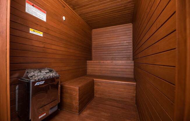 A wooden sauna with a bench and a hot tub.
