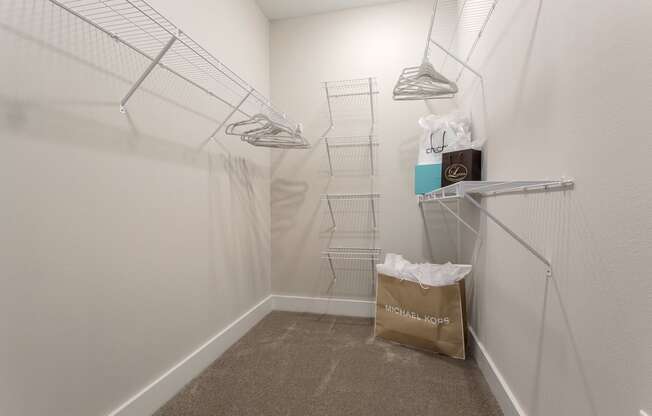 a walk in closet with a bag of groceries on the floor and a white wall