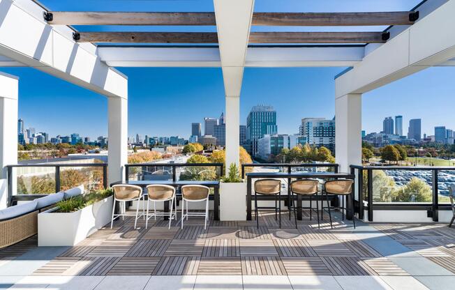 Pergola-covered rooftop seating at Modera Westside Trail with skyline views, bar-height tables, and open-air areas designed for gathering or downtime.