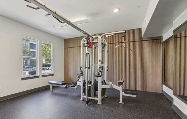 A gym with a weight machine and a bench.