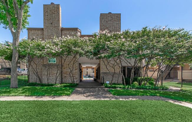 a large lawn in front of a brick building