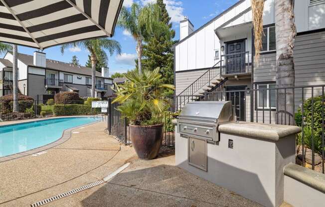 a backyard with a swimming pool and a barbecue grill