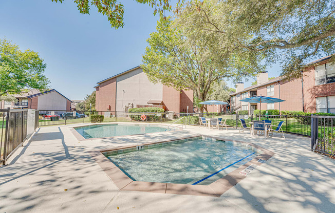 A swimming pool surrounded by trees and chairs.
