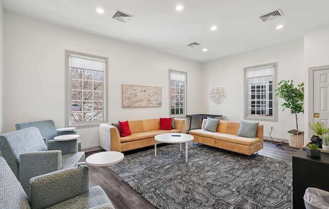 A living room with a couch, chairs, and a rug.