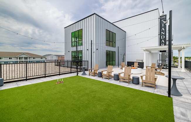 a patio with lawn chairs and a building with a sign on it at The Standard on 32nd, West Fargo, ND, 58078