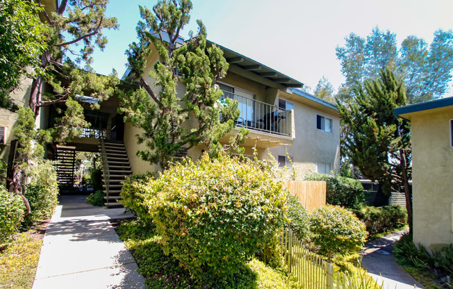 the exterior of a house with a sidewalk and a yard