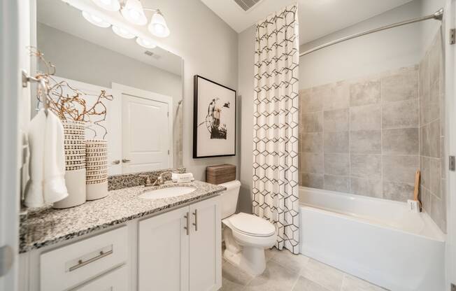 a bathroom with a toilet and a tub and a sink