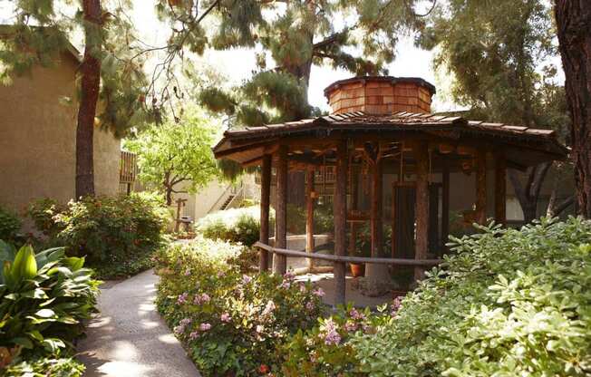 a bird aviary in a garden with plants and trees