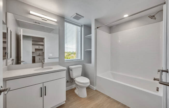 A white bathroom with a toilet, sink, and bathtub.
