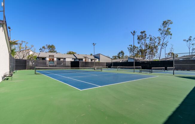 A tennis court with a blue surface and green edges.