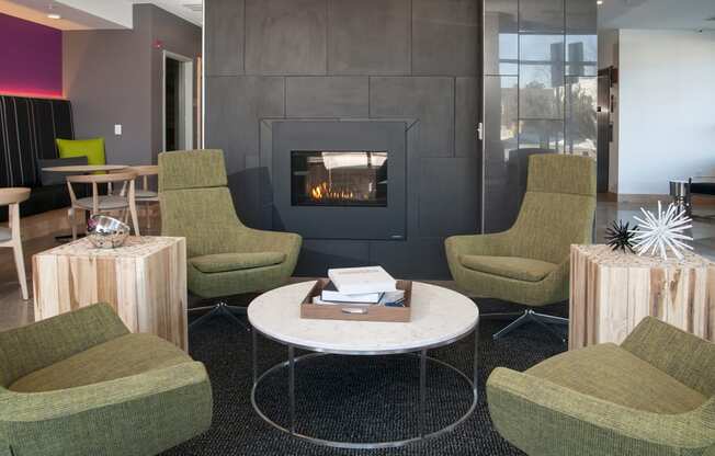 a living room with green chairs and a fireplace