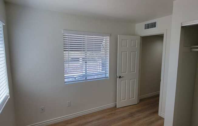 Bedroom with lots of natural light and large closets in one bedroom apartment at the Atrium Apartments in San Diego.