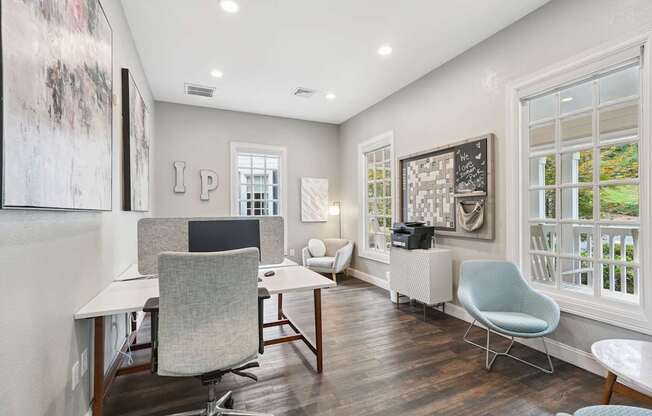 A room with a desk, chair, and a window with a view of a lawn.