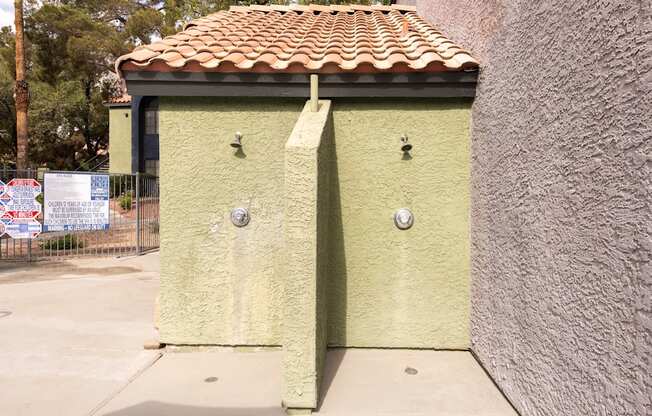 a small yellow building with a tiled roof and two doors