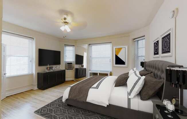 bedroom with bed, dresser, night stands, tv, ceiling fan and large windows at the calvertion apartments in washington dc
