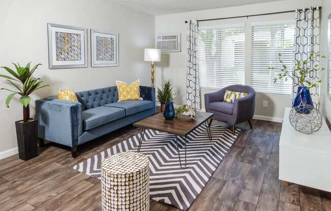 Apartments for Rent in Downey - Park Regency Club - Spacious Living Room with Light Grey Walls, Wood-Style Flooring, and Large Window