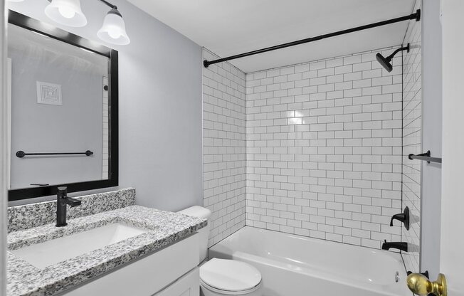 the preserve at ballantyne commons apartment bathroom with tub and sink and mirror