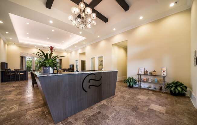 a lobby with a reception desk and a chandelier