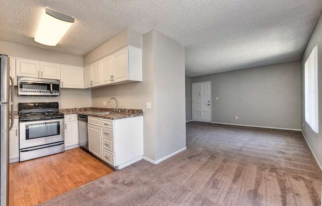 Two Bedroom Dining Room and Kitchen with wall to wall carpet, white cabinetry and stainless steel appliances