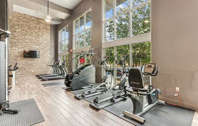 A gym with a brick wall and a row of exercise bikes.