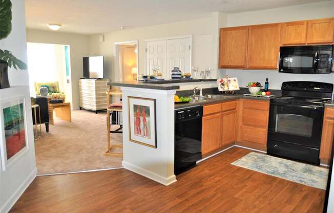 A kitchen with black appliances and wooden cabinets.