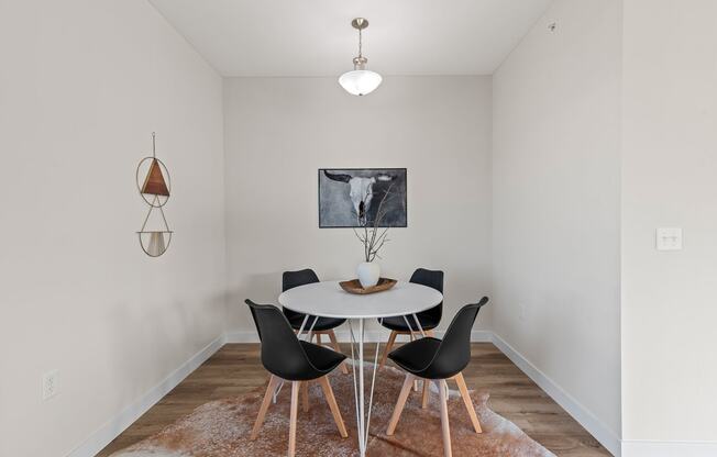 a dining room with a white table and chairs at The Residences Apartments at Bear Tree | DeForest, WI, DeForest, WI 53532