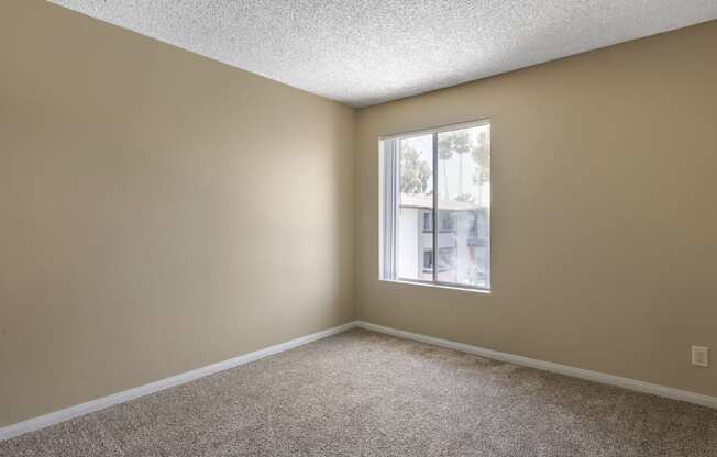 an empty bedroom with a large window