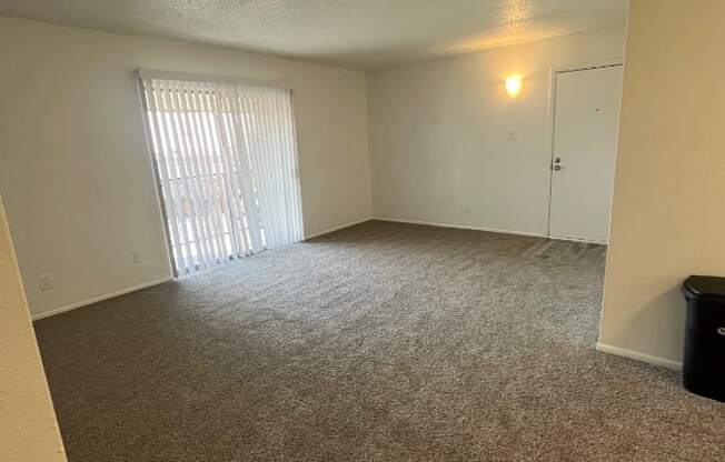 an empty living room with a sliding glass door
