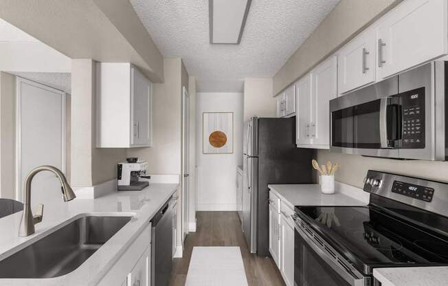 A modern kitchen with black appliances and white cabinets.
