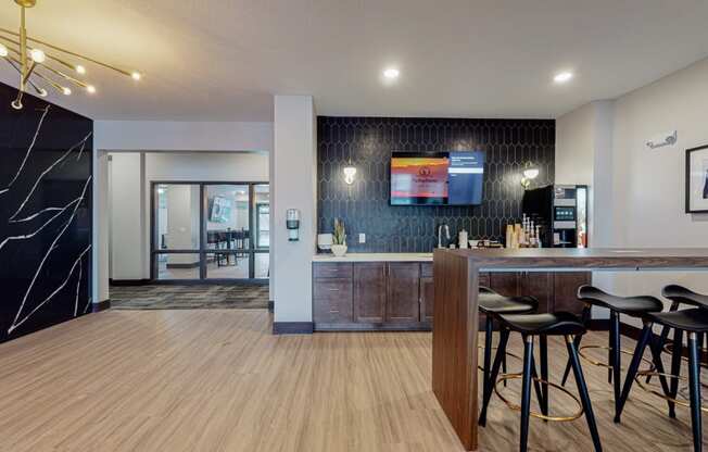 a bar area with stools and a counter with a television on the wall