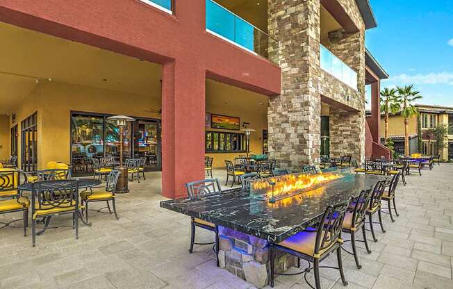 A patio with a table and chairs is surrounded by a building.