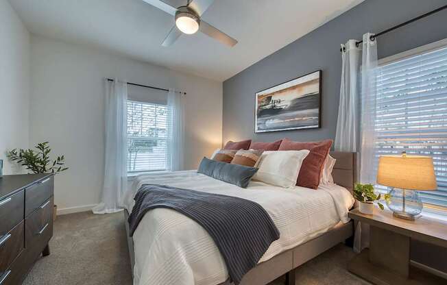 A bedroom with a bed, nightstand, and a ceiling fan.