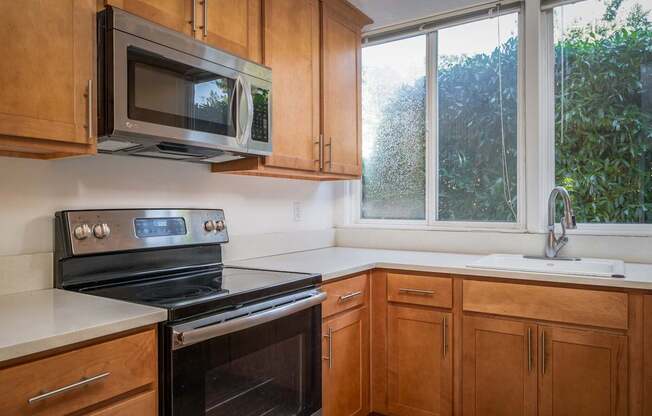 A kitchen with wooden cabinets and a black stove top oven.