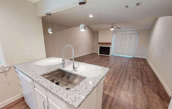 A kitchen with a granite countertop and a sink.