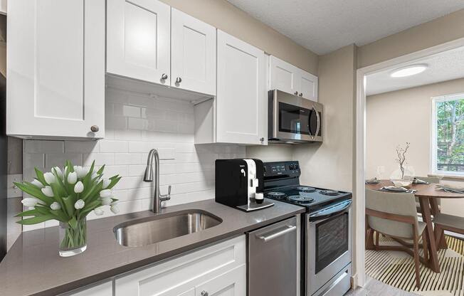 a kitchen with a sink and a stove and a microwave