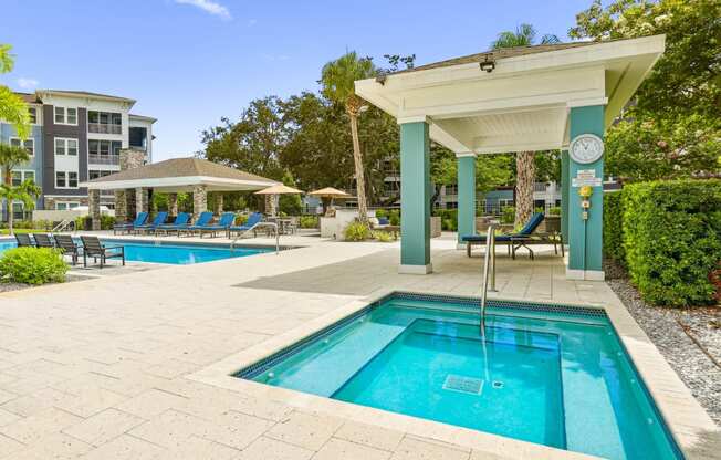 Jacuzzi with shaded seating area by the pool at Dunedin Commons apartments in Dunedin, FL