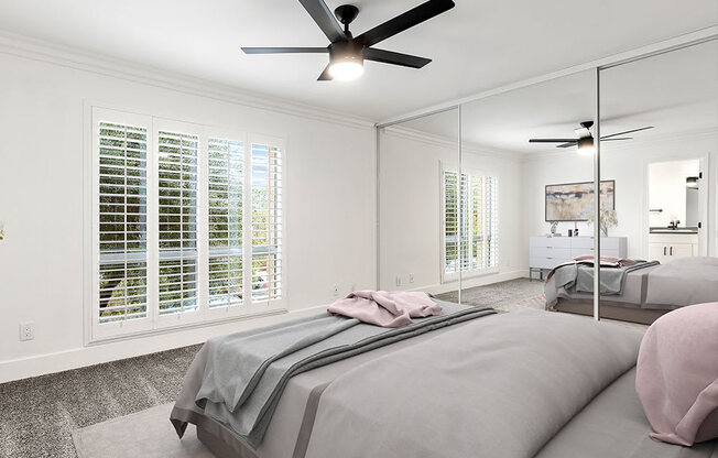 Carpeted bedroom with ceiling fan and large natural light window..