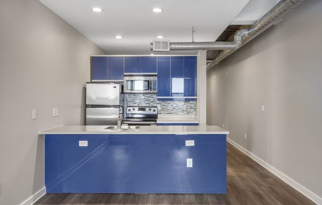 Our Apartment Kitchen with Blue Cabinets at Sleek Lofts Apartments in Denver, Colorado