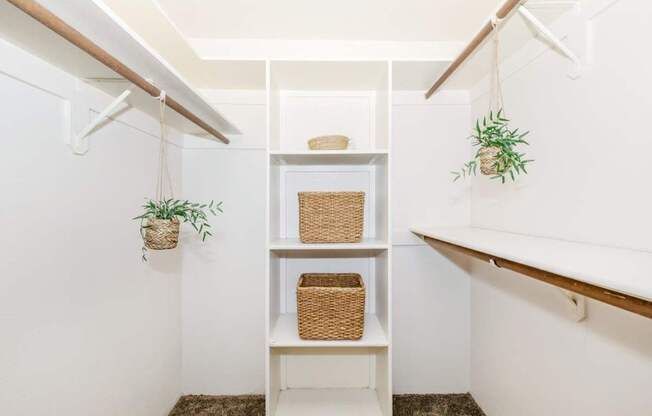 A white shelf with a basket and a plant on it.