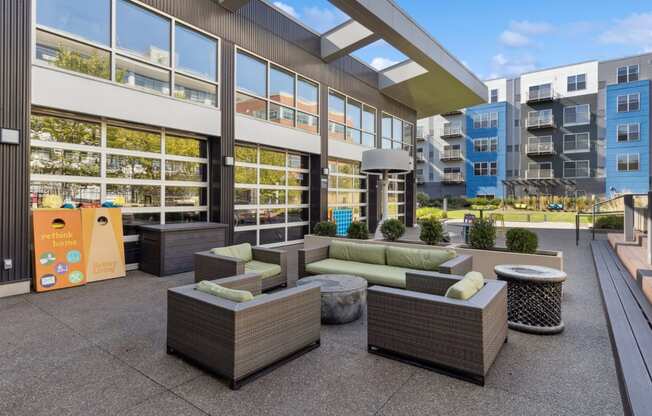 an outdoor patio with couches and tables in front of a building at Bakery Living, Pittsburgh, PA