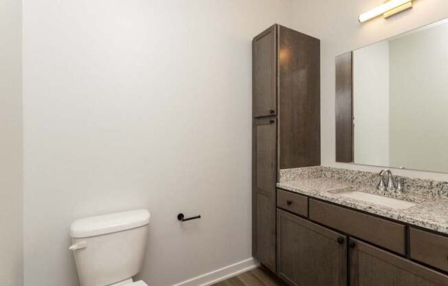 A bathroom with a toilet, sink, and medicine cabinet.