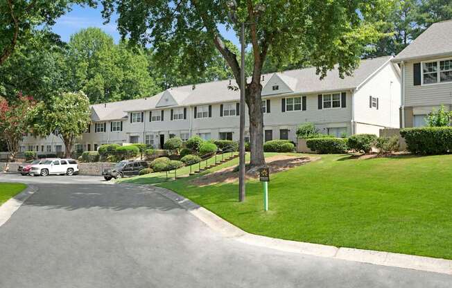 A tree stands in front of a white building. at Dunwoody Glen, Atlanta, GA