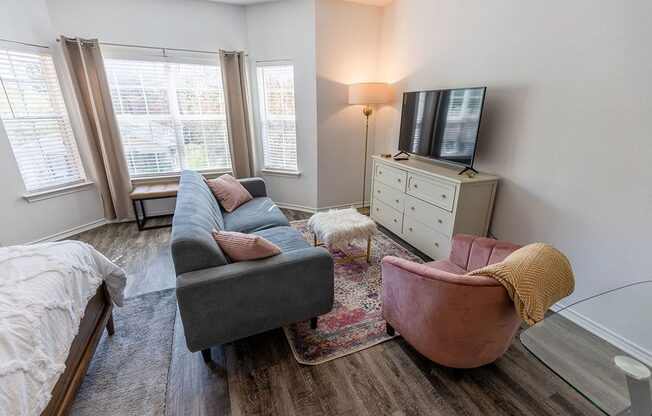 a living room with a couch and chair and a tv on a dresser