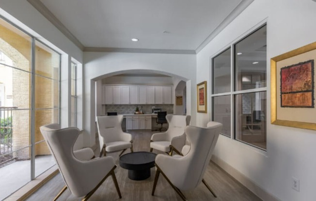 A modern living room with white furniture and a large window.