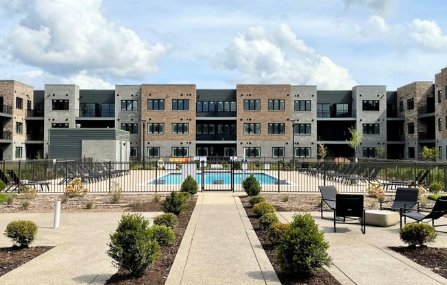 an exterior view of an apartment complex with a swimming pool