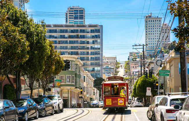 a red streetcar travels down a street in san francisco