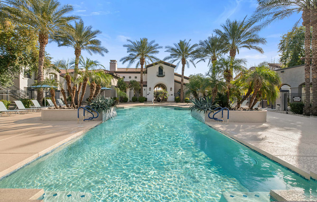 A long rectangular pool with a white border and a white concrete ledge on the side.