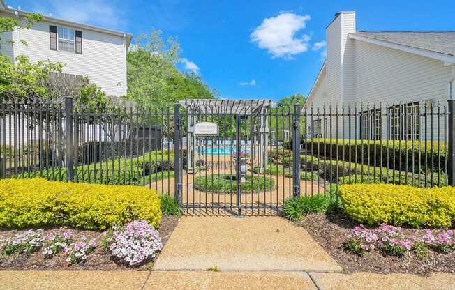 a garden with a pool behind a wrought iron fence at Reserve of Jackson Apartment Homes, Jackson, 39211