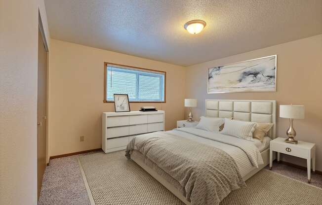 a bedroom with a bed and a dresser. Fargo, ND Kennedy Apartments